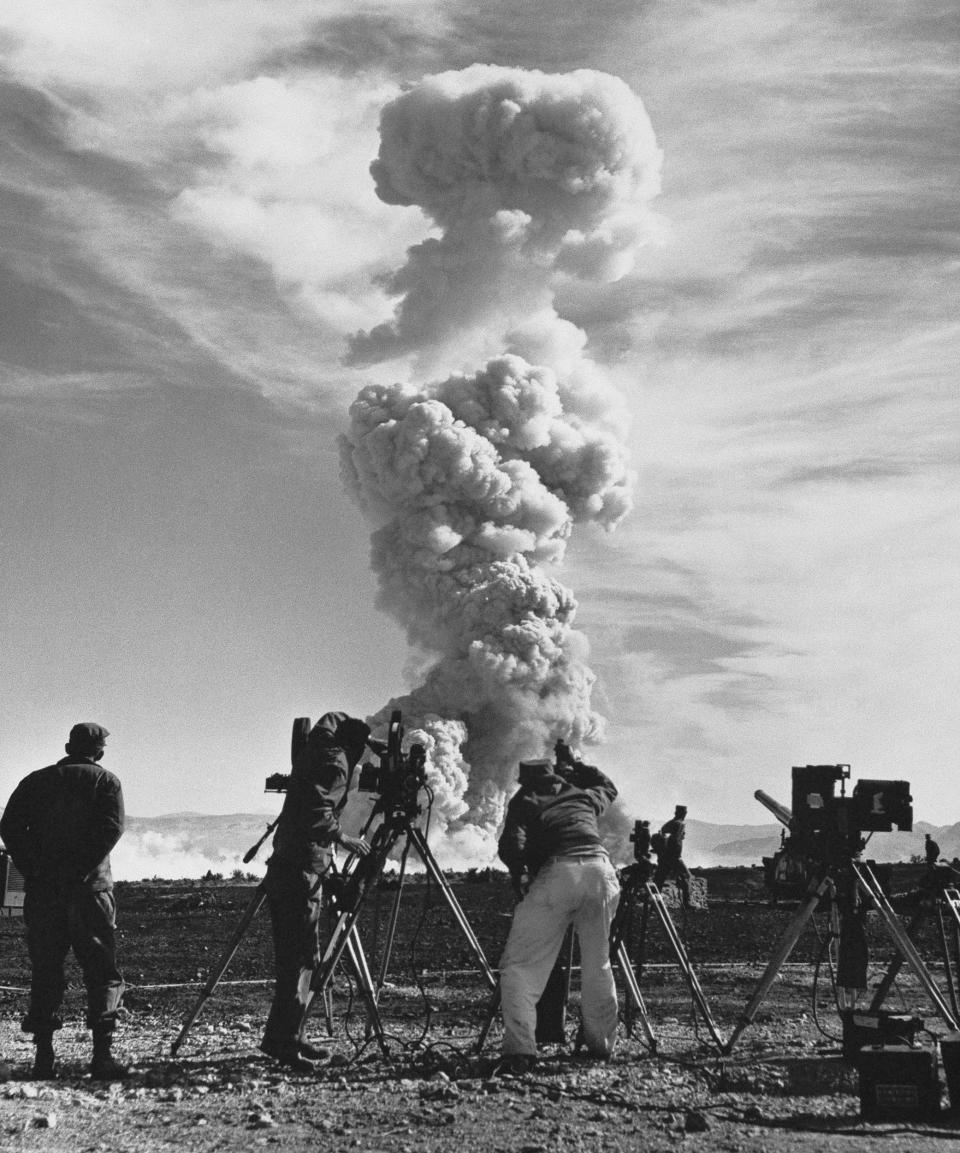 film crews photograph an atom cloud forming after an atomic shell fired a test in the Nevada desert