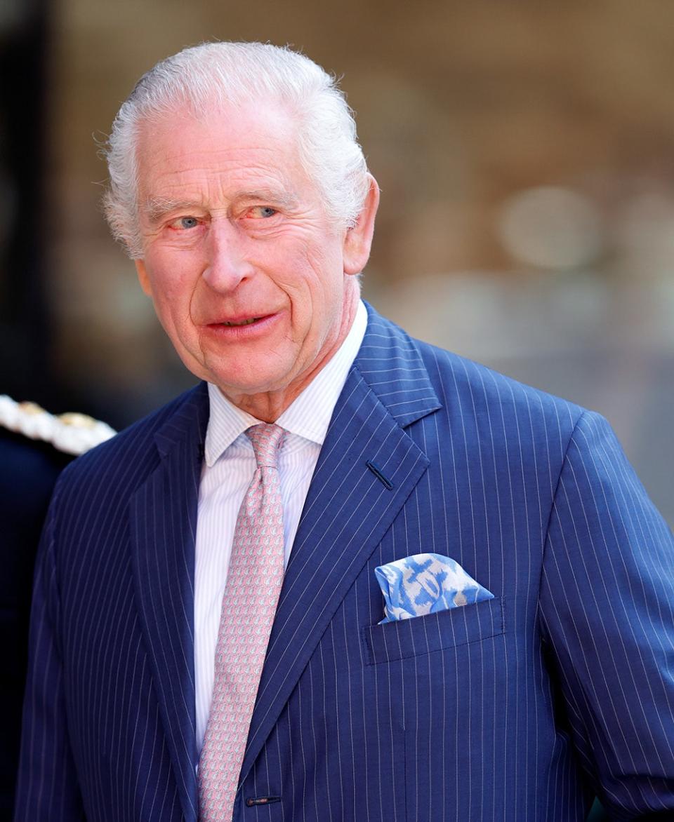 King Charles wearing a blue suit and a salmon pink tie