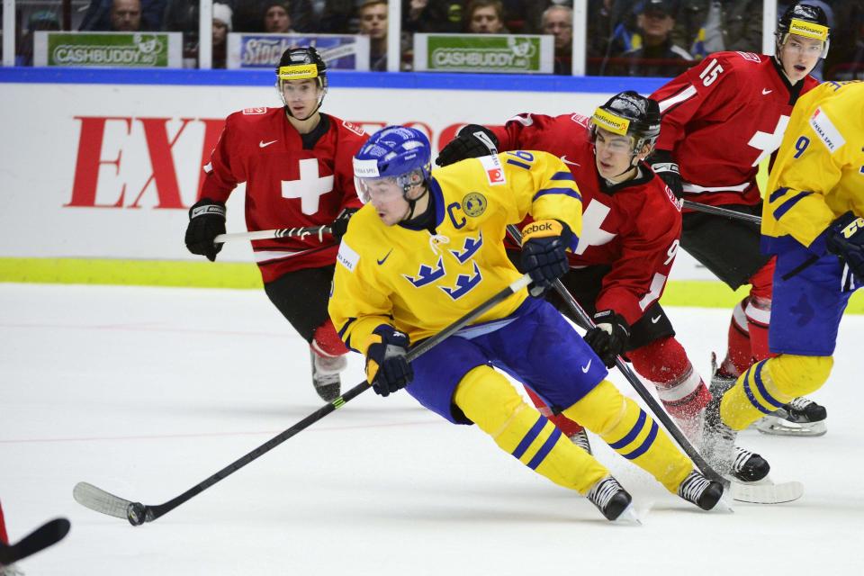 Sweden's Filip Forsberg is chased by Switzerland's Samuel Kreis during their IIHF World Junior Hockey Championship ice hockey game in Malmo December 26, 2013. REUTERS/Ludvig Thunman/TT News Agency (SWEDEN - Tags: SPORT ICE HOCKEY) ATTENTION EDITORS - THIS IMAGE WAS PROVIDED BY A THIRD PARTY. THIS PICTURE IS DISTRIBUTED EXACTLY AS RECEIVED BY REUTERS, AS A SERVICE TO CLIENTS. SWEDEN OUT. NO COMMERCIAL OR EDITORIAL SALES IN SWEDEN. NO COMMERCIAL SALES