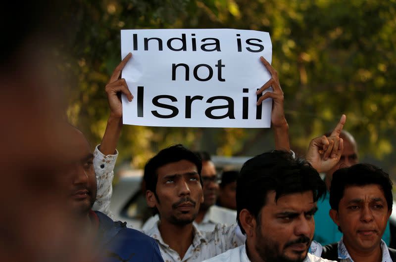 A demonstrator displays a placard during a protest against the Citizenship Amendment Bill, in Ahmedabad