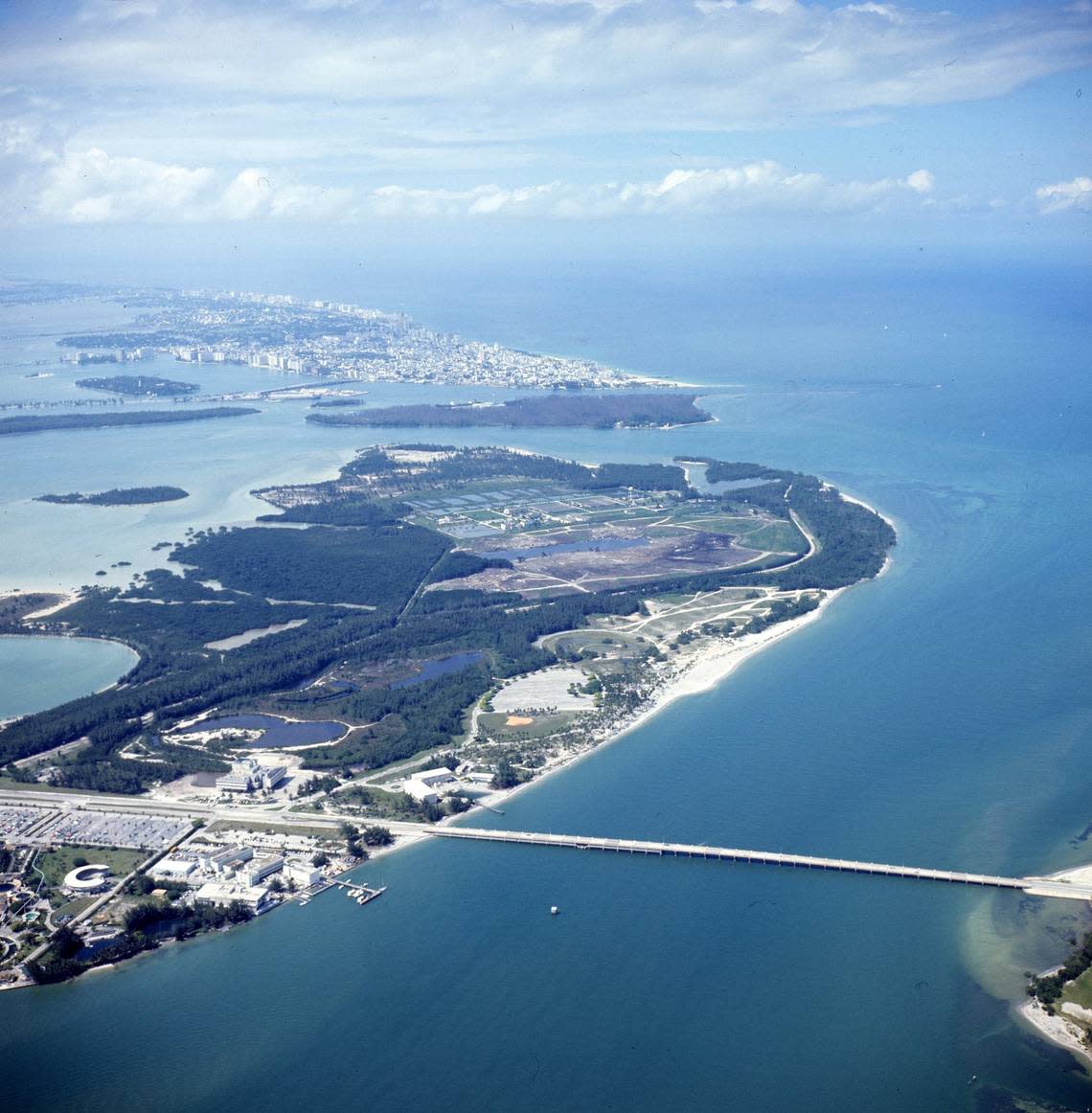 A 1972 aerial view of Virginia Key, showing the scope of Virginia Key, the historic Virginia Key Beach Park and the Rickenbacker Causeway in the foreground. Fisher Island, which had not been developed yet, is the island behind Virginia Key. Miami Beach is in the background, facing the Atlantic Ocean.