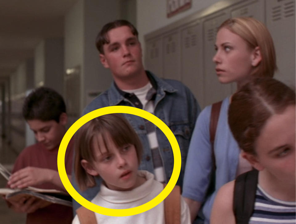 A young Kristen circled standing in line with other students in the school hallway