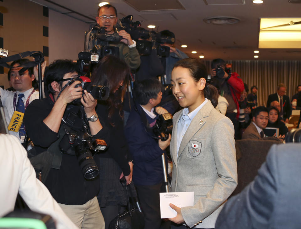 Japanese figure Skater Mao Asada leaves the packed press conference room at the Foreign Correspondents' Club of Japan in Tokyo Tuesday, Feb. 25, 2014 upon returning from Sochi, Russia. Asada says there is a 50-50 chance she will continue her career after an impressive performance in the free skate at the Sochi Olympics. Asada fell on her trademark triple axel to finish a disappointing 16th after the short program in Sochi but came back strong in the free skate, recording a season's best of 142.71 that gave her a total of 198.22 points for sixth place. (AP Photo/Koji Sasahara)