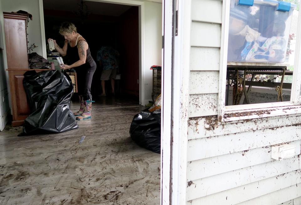 The high water mark can still be seen as Loretta Moses recovers art supplies out of a cabinet in her Sharon Way home in the Rossmoor community in Monroe Township Monday morning, August 23, 2021.  Her home was damaged by flooding over the weekend.