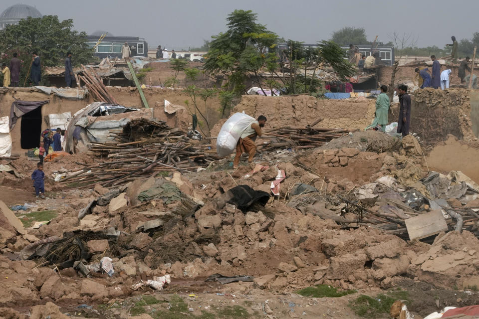 Afghans retrieve useful stuff from their damaged mud homes demolished by authorities during a crackdown against an illegal settlement and immigrants, on the outskirts of Islamabad, Pakistan, Wednesday, Nov. 1, 2023. (AP Photo/Anjum Naveed)