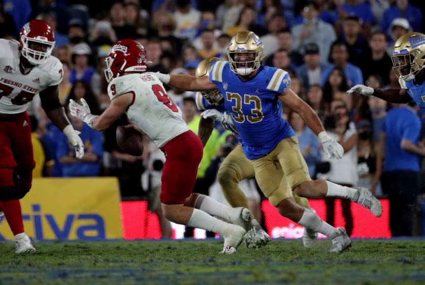 PASADENA, CA - SEPTEMBER 18, 2021:Fresno State Bulldogs quarterback Jake Haener (9) eludes the oncoming rush of UCLA Bruins linebacker Bo Calvert (33) at the Rose Bowl on September 18, 2021 in Pasadena, California.(Gina Ferazzi / Los Angeles Times)