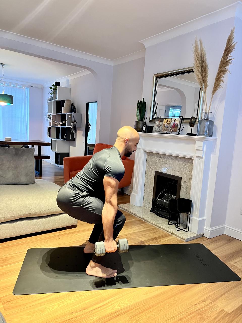 Personal trainer Ali Malik demonstrating the  suitcase squat