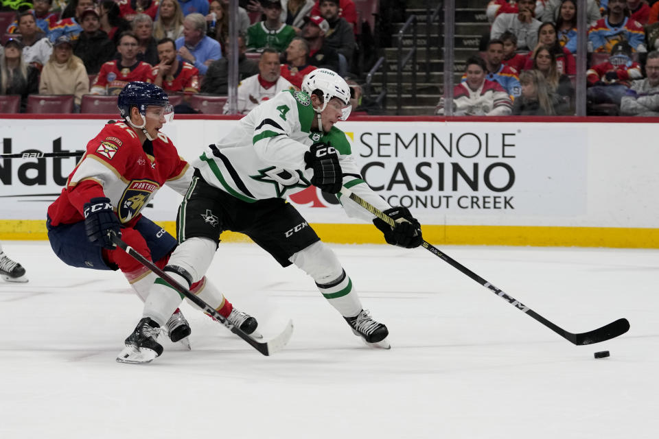 Dallas Stars defenseman Miro Heiskanen (4) attempts a shot on the gaol as Florida Panthers defenseman Gustav Forsling (42) defends during the first period of an NHL hockey game, Wednesday, Dec. 6, 2023, in Sunrise, Fla. (AP Photo/Lynne Sladky)