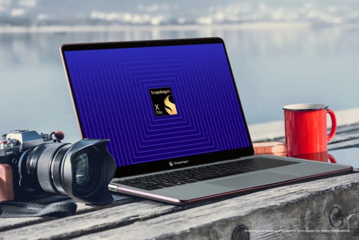 A laptop and a camera on a table with a Qualcomm logo on the screen.