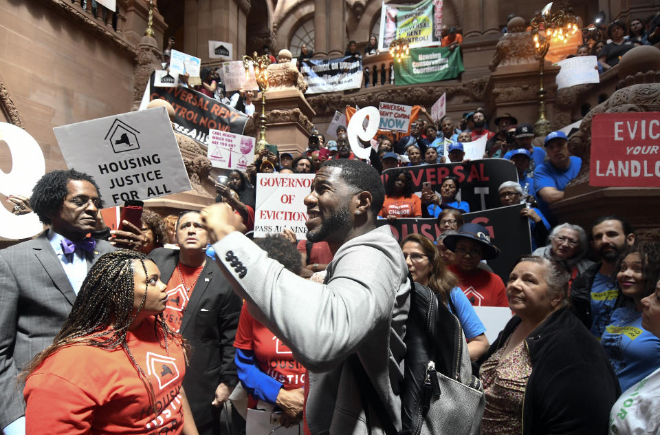 Jumaane Williams, Public Advocate for the City of New York, center, speaks with tenants and members of the Upstate Downstate Housing Alliance from across the state, demanding New York Gov. Andrew Cuomo and state legislators pass universal rent control legislation that would strengthen and expand tenants rights across the state of New York before rent laws expire on June 15th during a protest rally at the state Capitol Tuesday, June 4, 2019, in Albany, N.Y. (AP Photo/Hans Pennink)