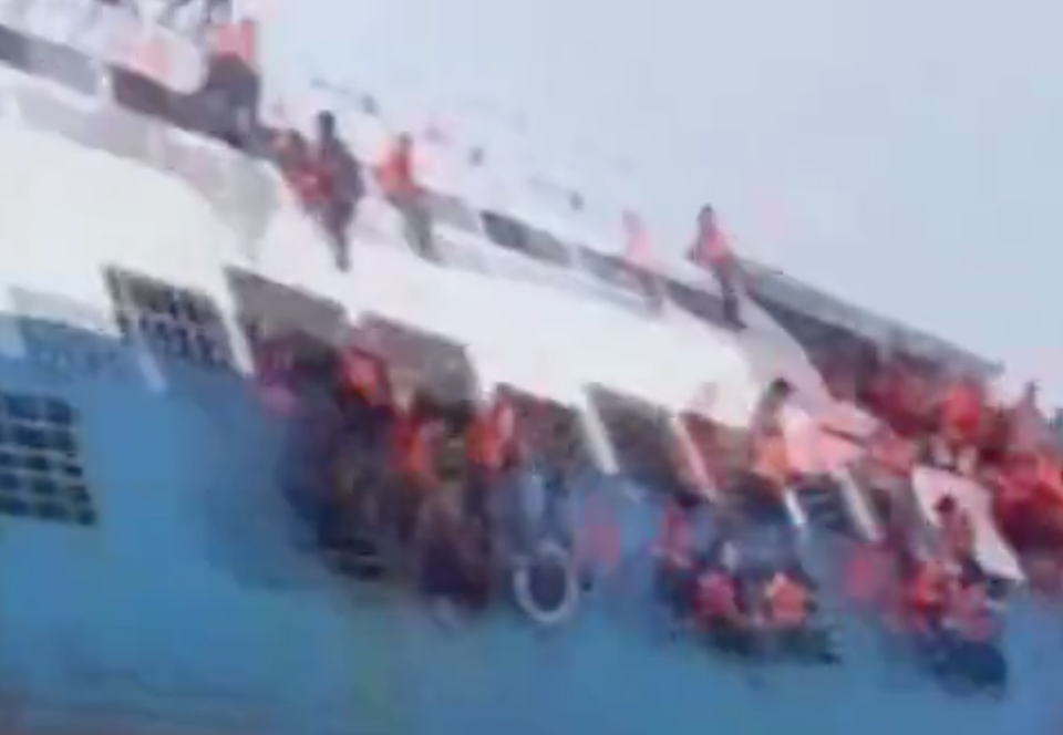 <em>Terrified – dramatic footage shows people clinging on to the side of the ferry as it sinks off the coast of Indonesia (Picture: Reuters)</em>