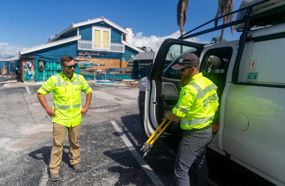 James Fountain, de 40 años, a la derecha, y David Hough, de 30 años, ambos del Servicio Geológico de Estados Unidos, llegan a Nauti Parrot Dock Bar el martes 18 de octubre de 2022, en Fort Myers Beach, Florida.