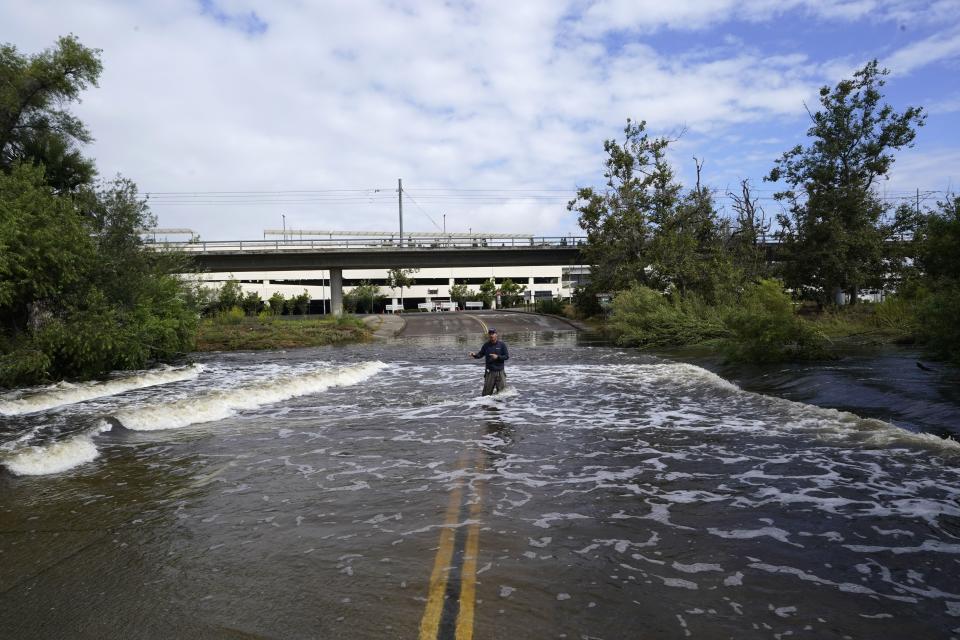 A television reporter stands in a flooded road after the passing of Tropical Storm Hilary, Monday, Aug. 21, 2023, in San Diego. | Gregory Bull, Associated Press