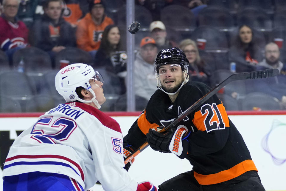 Montreal Canadiens' Justin Barron, left, and Philadelphia Flyers' Scott Laughton watch a loose puck during the second period of an NHL hockey game, Friday, Feb. 24, 2023, in Philadelphia. (AP Photo/Matt Slocum)