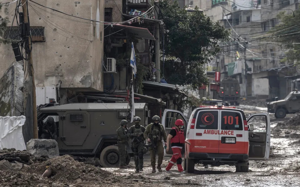 Israeli soldiers prepare to check a Palestinian Red Crescent ambulance at the entrance of the Tulkarm reugee camp