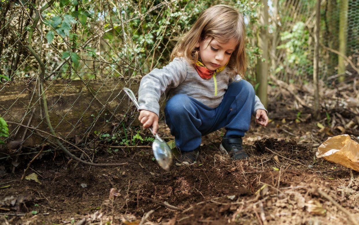 A child playing outside in dirt