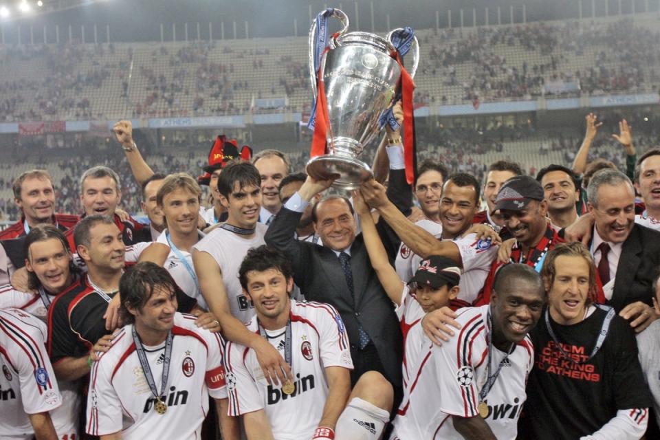 Berlusconi raises the Champions League trophy aloft alongside AC Milan players after they beat Liverpool 2-1 in the 2007 final (AP)