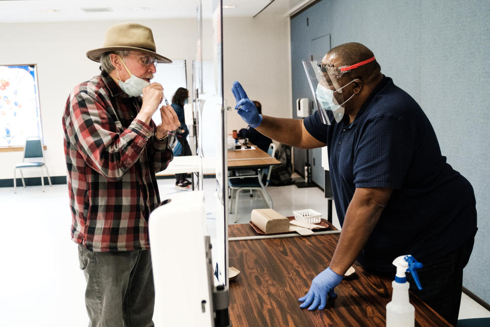 Un hombre recibe instrucciones para realizar una prueba PCR para detectar la COVID-19 a partir de la saliva en un sitio comunitario de pruebas en Davis, California, el 25 de enero de 2021. (Max Whittaker/The New York Times)
