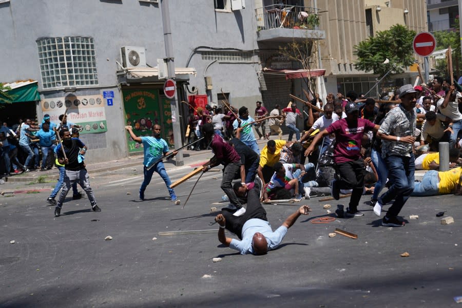 Anti-Eritrean government activists, left, clash with supporters of the Eritrean government, in Tel Aviv, Israel, Saturday, Sept. 2, 2023. (AP Photo/Ohad Zwigenberg)