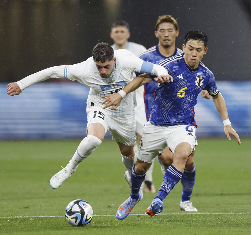 Federico Valverde de Uruguay y Wataru Endo de Japón pelean por el balón en el encuentro amistoso en el Estadio Nacional de Tokio, Japón el viernes 24 de marzo del 2023. (Kyodo News via AP)