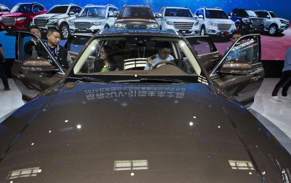 In this photo taken Monday, April 25, 2016, visitors to the Auto China 2016 examine the latest SUV from Chinese automaker Haval in Beijing, China. Industry figures released Jan 12, 2017, show China's auto market had a bumper year in 2016 as sales grew by 15 percent, with drivers rushing to buy cars before a tax break expired at the end of the year. (AP Photo/Ng Han Guan)