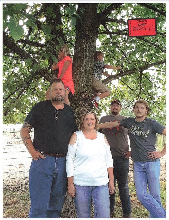 The Wagner family gathers at Flying W Farms, the Lucasville, Ohio, horse-breeding business owned by Fredericka Wagner and her late husband, Bob Wagner. From left are George "Billy" Wagner III, Angela Wagner, George Wagner IV and Edward "Jake" Wagner. Sitting in the tree is Sophia Wagner, the daughter of Jake Wagner and Hanna May Rhoden, and Bulvine Wagner, the son of George Wagner IV and former wife Tabitha Claytor. Special Prosecutor Angela Canepa showed this undated photo during the fall 2022 murder trial of George Wagner IV.