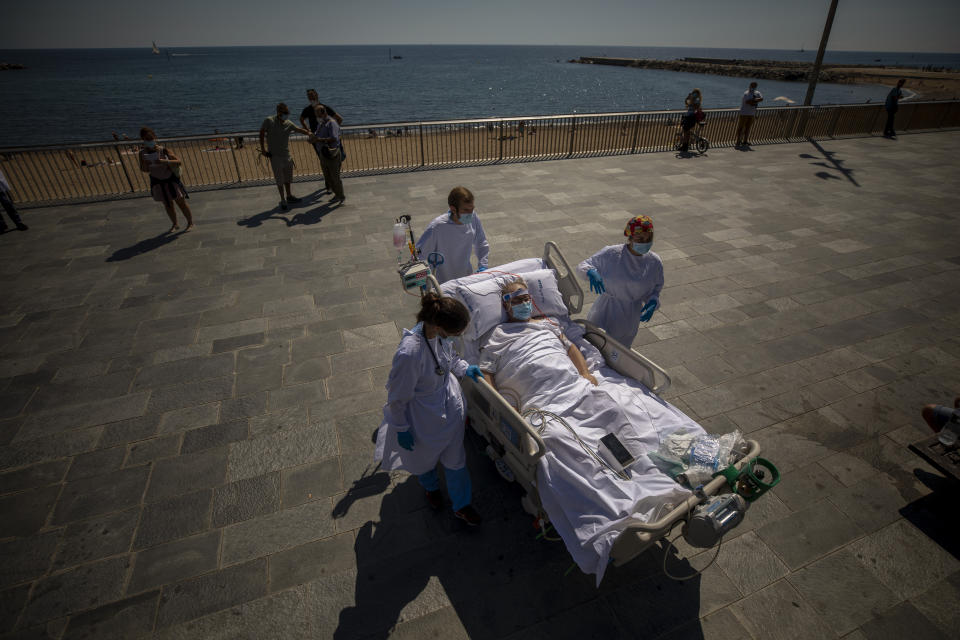 Francisco España, 60, is transported back to the hospital after spending a few minutes by the promenade, in Barcelona, Spain, Friday, Sept. 4, 2020. A hospital in Barcelona is studying how short trips to the beach may help COVID-19 patients recover from long and traumatic intensive hospital care. The study is part of a program to “humanize” ICUs. Since re-starting it in early June, the researchers have anecdotally noticed that even ten minutes in front of the blue sea waters can improve a patient’s emotional attitude. (AP Photo/Emilio Morenatti)
