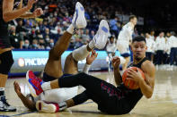 Pennsylvania's Jelani Williams, right, hangs onto a loose ball as Villanova's Eric Dixon falls over during the first half of an NCAA college basketball game, Wednesday, Dec. 1, 2021, in Philadelphia. (AP Photo/Matt Slocum)