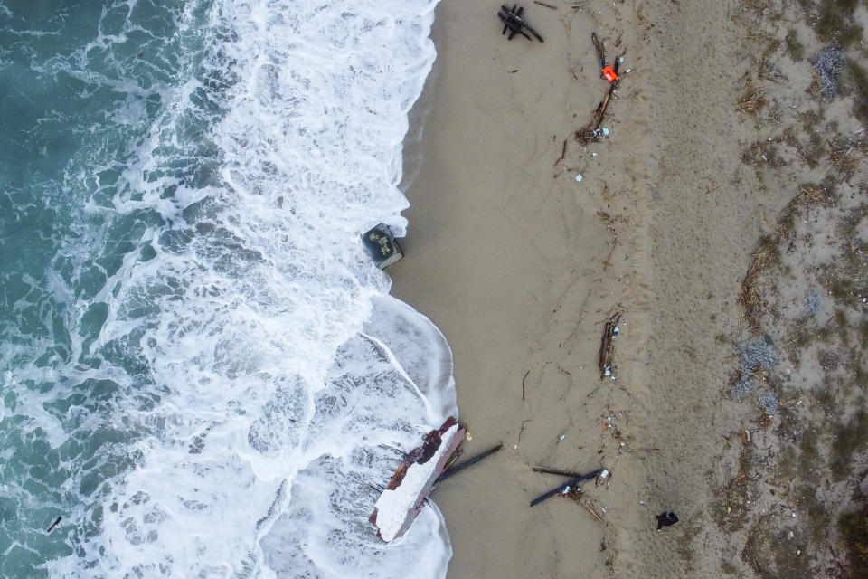 A view of part of the wreckage of a capsized boat that was washed ashore at a beach near Cutro, southern Italy, Monday, Feb. 27, 2023. Rescue crews searched by sea and air Monday for the dozens of people believed still missing from a shipwreck off Italy’s southern coast that drove home once again the desperate and dangerous crossings of migrants seeking to reach Europe. (AP Photo/Luigi Navarra)