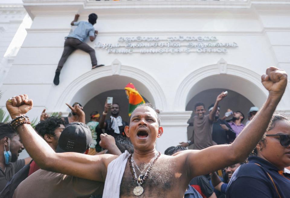 Demonstrators celebrate after they entered into Sri Lankan Prime Minister Ranil Wickremasinghe's office during a protest demanding for his resignation (Dinuka Liyanawatte/Reuters)