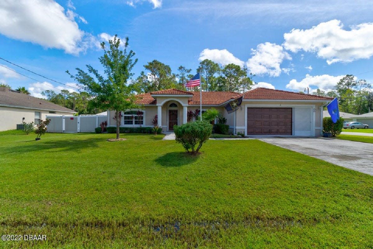 This well-maintained 2017 home in Palm Coast sits on a corner lot, adorned with beautiful landscaping.