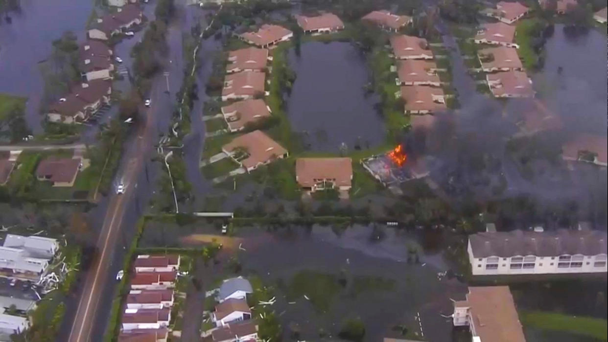 A aerial view of flooded homes, some of them inundated to the point where just the roofs are showing.