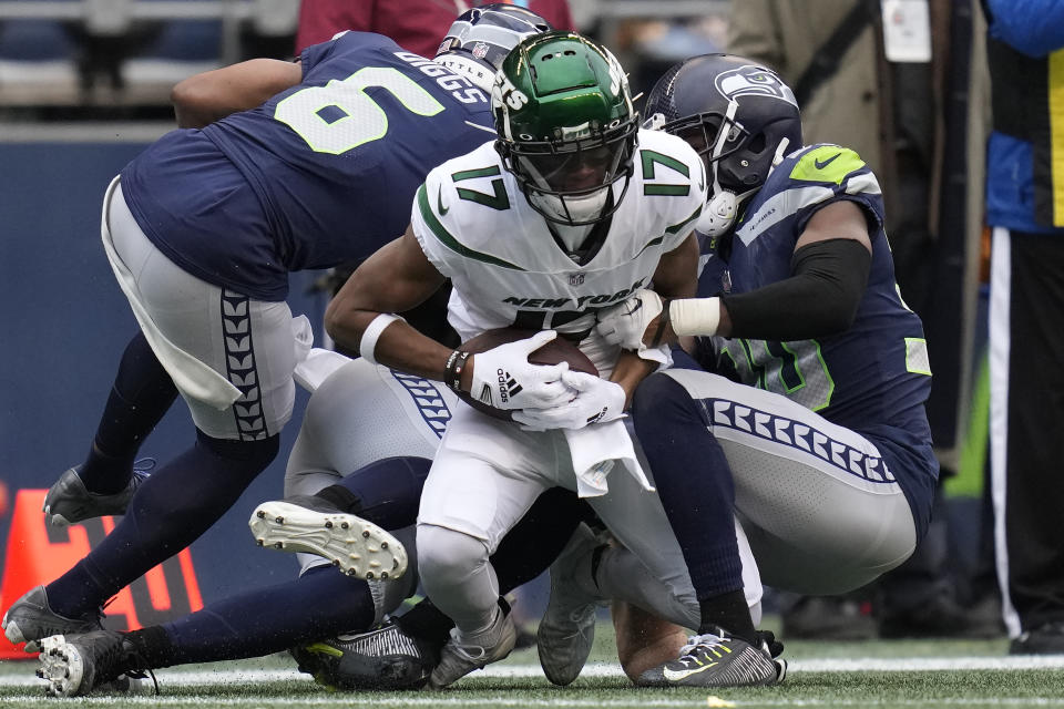 New York Jets wide receiver Garrett Wilson (17) makes a catch as Seattle Seahawks safety Quandre Diggs (6) makes the hit during the first half of an NFL football game, Sunday, Jan. 1, 2023, in Seattle. (AP Photo/Godofredo A. Vásquez)