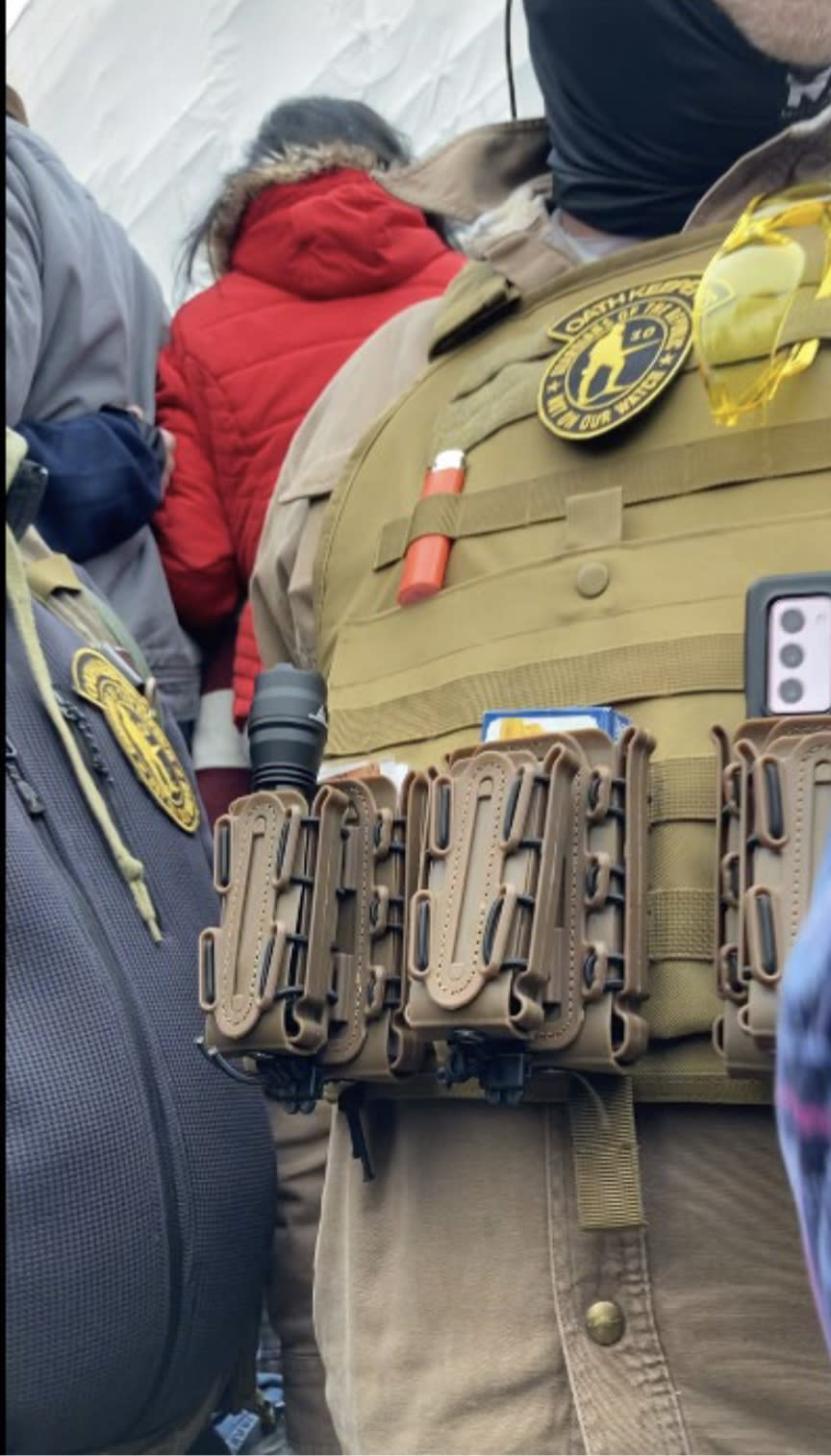 Images 4 and 5: Side-by-side stills from Munchel’s cell phone camera video (Exhibit 301 at 12:00 and 12:02, respectively) capturing the Oath Keepers’ interactions with Eisenhart and Munchel’s fist bump with one of them