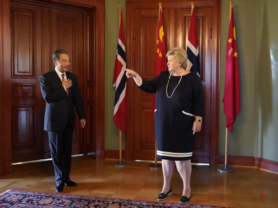 China's Foreign Minister Wang Yi, left, is welcomed by Norway Prime Minister Erna Solberg during a short courtesy visit to Norway, in Oslo, Thursday Aug. 27, 2020. The visit by Wang Yi and his delegation is part of a tour to several European countries. (Heiko Junge / NTB scanpix via AP)