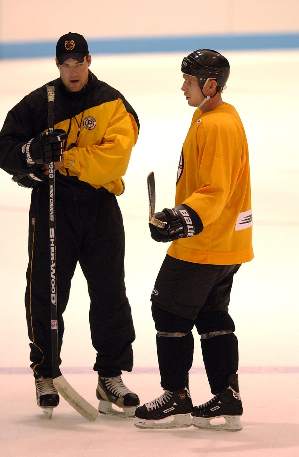 Then-head coach of the Providence Bruins, Bill Armstrong, left, talking with player Ben Carpentier during a 2001 practice.