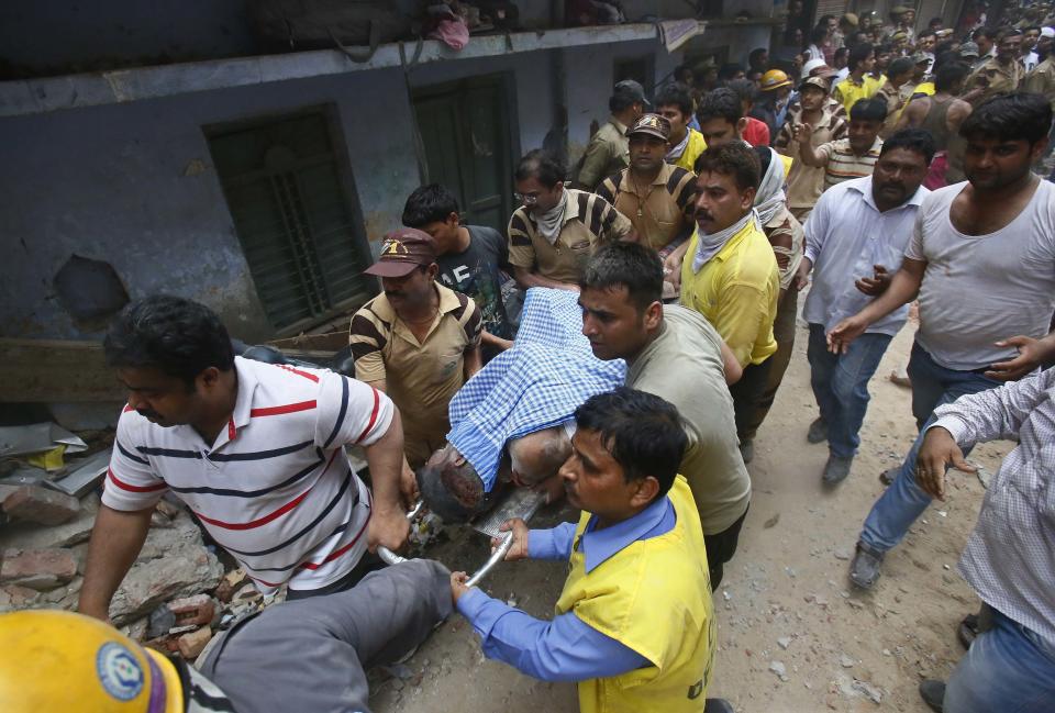 Injured man is taken to an ambulance from the site of a collapsed building in New Delhi