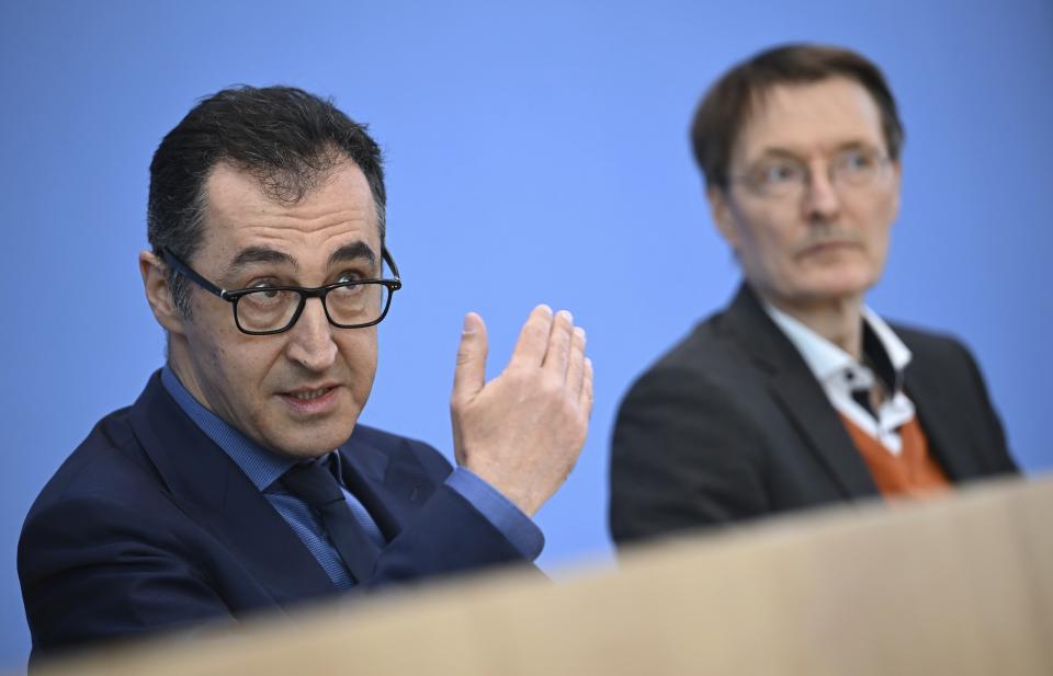 German Agriculture Minister Cem Ozdemir, left, and German Health Minister Karl Lauterbach, right, address the media during a press conference in Berlin, Germany, Wednesday, April 12, 2023. The German government on Wednesday presented scaled-back plans to liberalize the country's rules on cannabis, which would decriminalize possessing and growing limited amounts of the substance and allow its sale for recreational purposes to members of nonprofit 'cannabis clubs.' (Britta Pedersen/dpa via AP)