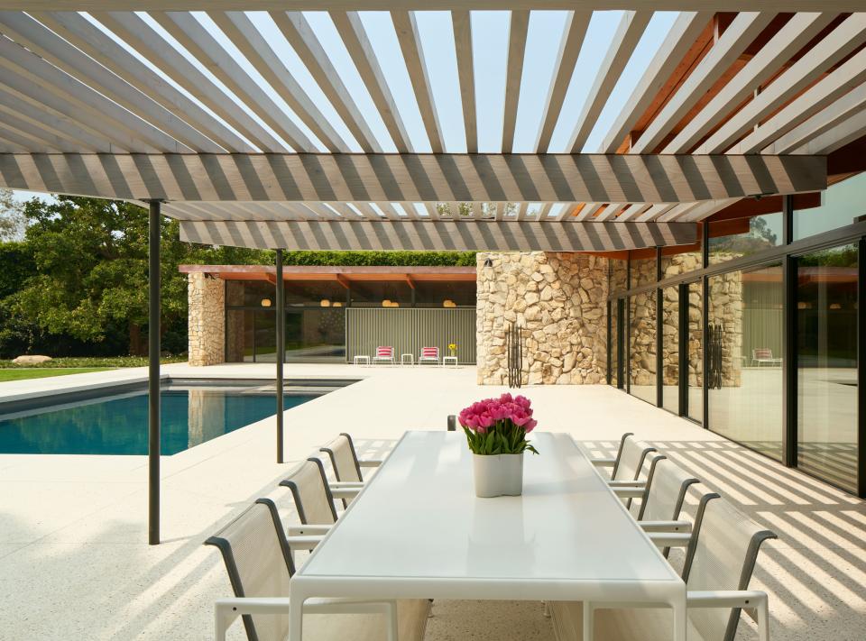 Redoing the pool was part of the property’s complete makeover. Here, under a new trellis, are a Knoll dining table and vintage Knoll chairs. In the distance are vintage Van Keppel-Green pool chaises.