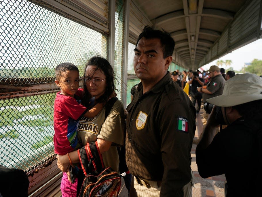 Migrants from a group of 50 who were chosen by the Casa Migrante organization, walk across the Puerto Nuevo bridge from Matamoros, Mexico