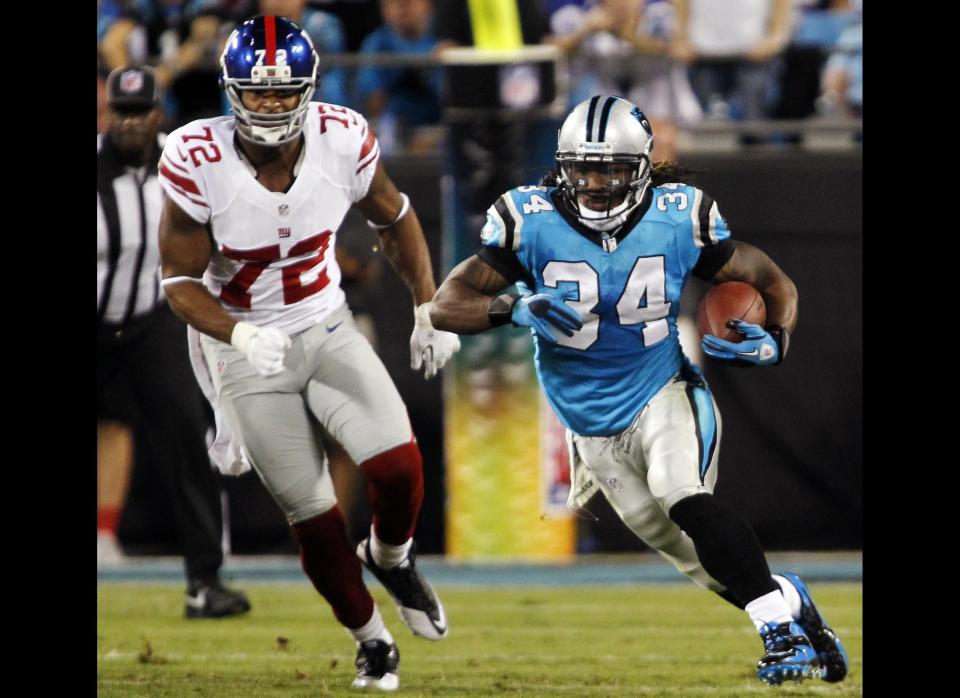 Carolina Panthers running back DeAngelo Williams (34) rushes past New York Giants defensive end Osi Umenyiora (72) during the first quarter of an NFL football game in Charlotte, N.C., Thursday, Sept. 20, 2012. 