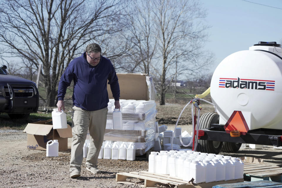 Russell Hall, with the Office of Emergency Management and Phillips County employees, distribute water for people without water Tuesday, Jan. 30, 2024, in Helena, Arkansas. Parts of the east Arkansas town has been without water for two weeks after the state was hit by below freezing temperatures, and residents have been lining up for jugs of water and a truck of mobile showers dispatched to the community. (AP Photo/Karen Pulfer Focht)