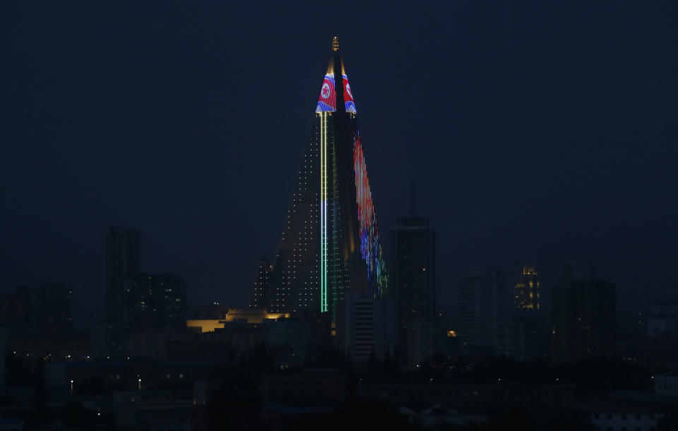 In this Oct. 21, 2018 photo, the 105-storey Ryugyong Hotel is illuminated in the night sky in Pyongyang, North Korea. Twenty years after his father almost bargained them away for a pair of nuclear reactors, North Korean leader Kim Jong Un has his nuclear weapons - and a nation still plagued by chronic blackouts. But years of sanctions have spurred the North to cobble together a creative smorgasbord of alternative resources, some off the official grid and some flat-out illegal. (AP Photo/Dita Alangkara)