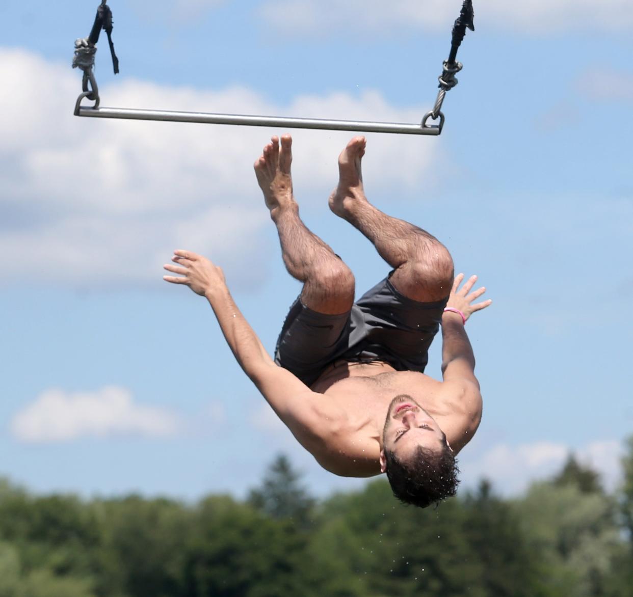 Ethan Klintworth does a backflip off the trapeze at Lake Cable in Jackson Township.