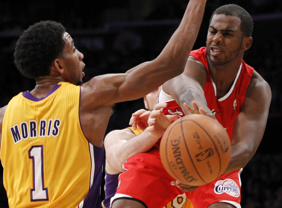 Los Angeles Clippers' Chris Paul, right, passes around Los Angeles Lakers' Darius Morris, left, during the first half of an NBA preseason basketball game in Los Angeles on Monday, Dec. 19, 2010. (AP Photo/Danny Moloshok)