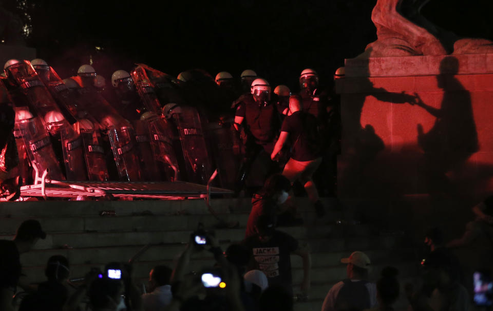 Protesters clash with riot police on the steps of the Serbian parliament during a protest in Belgrade, Serbia, Friday, July 10 2020. Serbia's President Aleksandar Vucic said Friday he's not worried about losing political power amid large protests against his handling of the coronavirus crisis and hard-line rule, but instead expressed his fear about the spread of the virus by the demonstrators. The spontaneous protests started on Tuesday when Vucic announced that Belgrade would be placed under a new three-day lockdown following a second wave of confirmed coronavirus infections. (AP Photo/Darko Vojinovic)