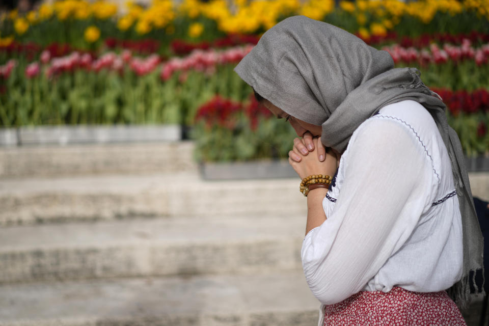 A faithful prays in St. Peter's Square at The Vatican where Pope Francis will celebrate the Easter Sunday mass, Sunday, March 31, 2024. (AP Photo/Andrew Medichini)