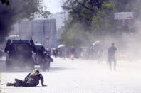 <p>A security force and a civilian lie low at the site of a suicide attack after the second bombing in Kabul, Afghanistan, April 30, 2018. (Photo: Massoud Hossaini/AP) </p>