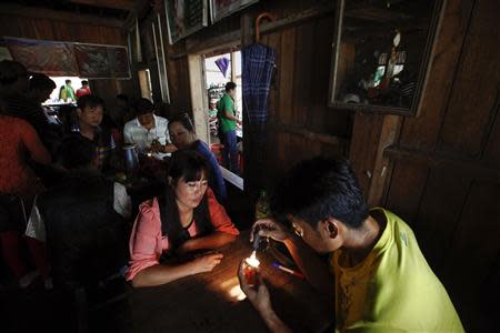 Traders inspect jade on so-called "jade tables" in a tea shop in Lone Khin village, in Hpakant township, Kachin State July 8, 2013. REUTERS/Minzayar