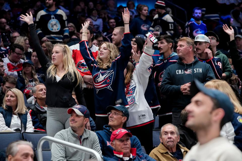 Oct 14, 2022; Columbus, Ohio, USA;  Columbus Blue Jackets fans appeal appeal for t-shirts being given out during the first period of the NHL hockey game against the Tampa Bay Lightningat Nationwide Arena. Mandatory Credit: Adam Cairns-The Columbus Dispatch